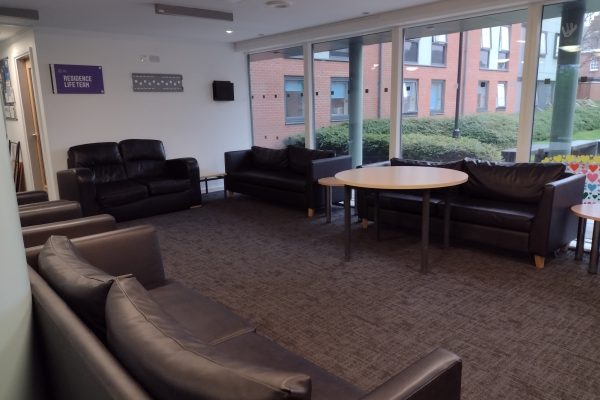 Communal social area in entrance of accomodation building. A selection of leatherette sofas and some tables.