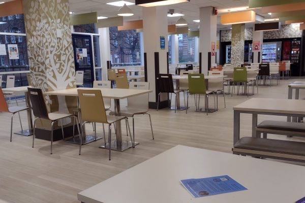 Food court with a cafe style selection of tables, chairs and benches on a laminated floor